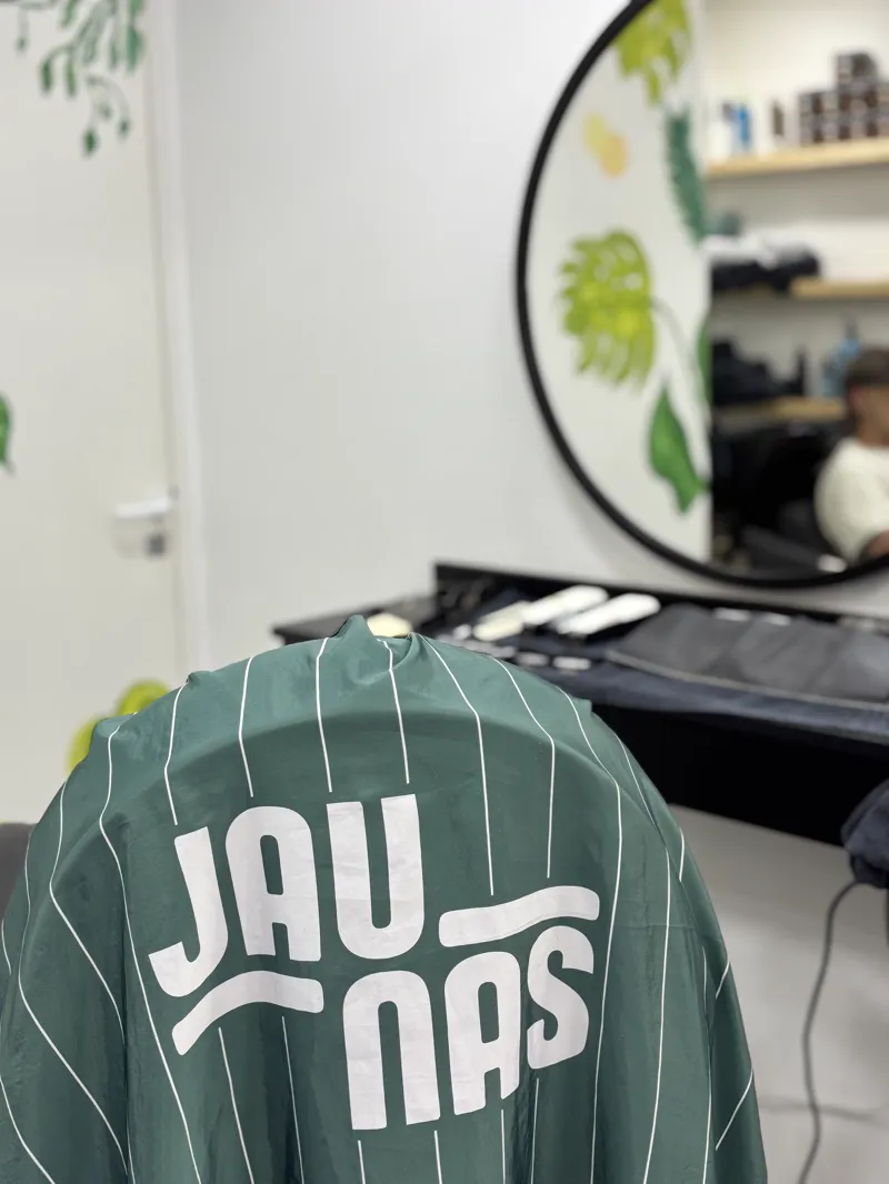 Capa verde a rayas con el logo de Jaunas en la espalda