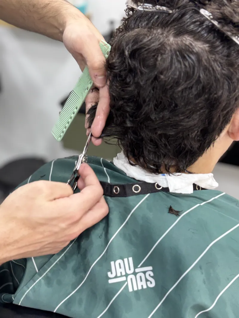Peluquero cortando el pelo con tijera y peine